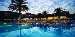 Entspannter Abend am Pool mit romantischem Ausblick auf das Hotel.