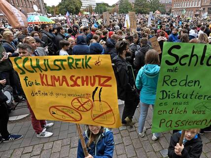 20.09.2019, Schleswig-Holstein, Kiel: Demonstranten der Bewegung Fridays for Future starten zu einem Demonstrationszug. Zwei Kinder halten Plakate mit der Aufschrift "Schulstreik für den Klimaschutz" und "Schluss mit Reden Diskutieren - es muss endlich was passieren!. Klimaschützer, Wissenschaftler und Gewerkschaften haben kurz vor der entscheidenden Sitzung des Klimakabinetts den Druck auf die Bundesregierung noch einmal erhöht. In Deutschland seien mehr als 500 Demonstrationen angemeldet, teilte die Bewegung Fridays for Future mit. Foto: Carsten Rehder/dpa +++ dpa-Bildfunk +++