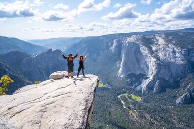 Zwei Menschen stehen an einer Klippe im Yosemite Nationalpark in den USA.